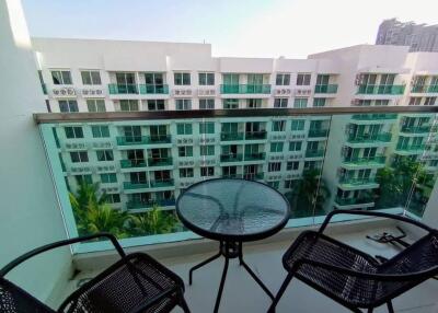 Modern apartment balcony with glass table and city view