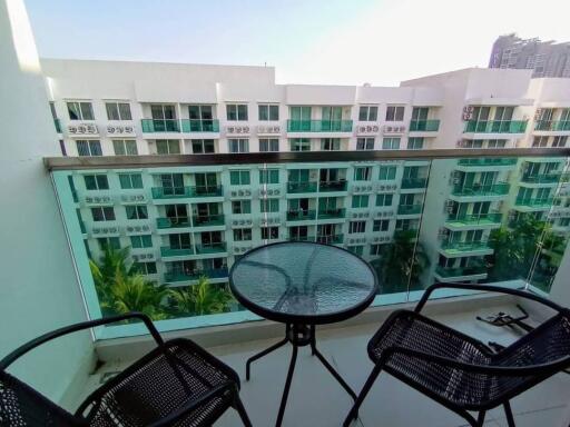 Modern apartment balcony with glass table and city view