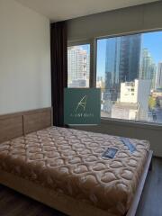 Bedroom with a large window and city view