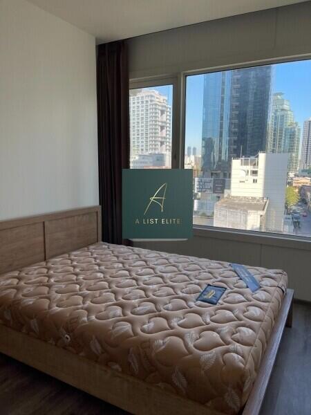 Bedroom with a large window and city view