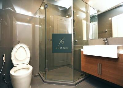 Modern bathroom with glass shower, toilet, and sink