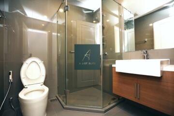 Modern bathroom with glass shower, toilet, and sink