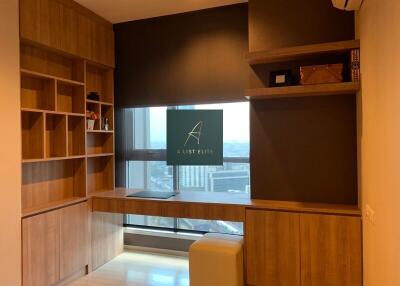 A study room with built-in wooden shelves and a view of the city