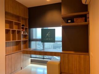 A study room with built-in wooden shelves and a view of the city