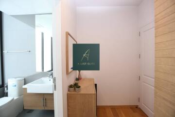 Modern bathroom with sink, toilet, and wooden cabinet