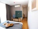 Bedroom with natural light, modern decor, and guitar on the bed