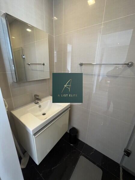 Modern bathroom with a sink, mirror cabinet, and tiled walls