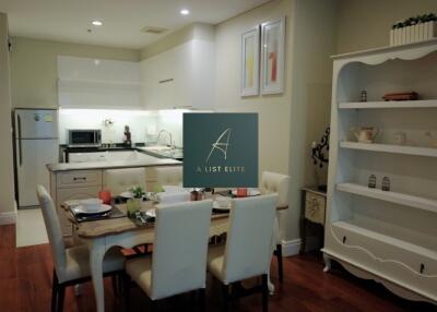 Modern kitchen and dining area with white cabinetry and wooden flooring