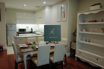 Modern kitchen and dining area with white cabinetry and wooden flooring