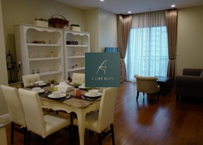 Living room with dining area, bookshelf, and natural light from window