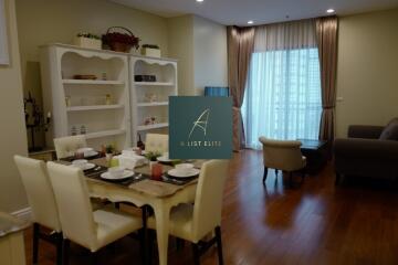 Living room with dining area, bookshelf, and natural light from window