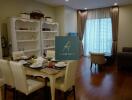 Living room with dining area, bookshelf, and natural light from window