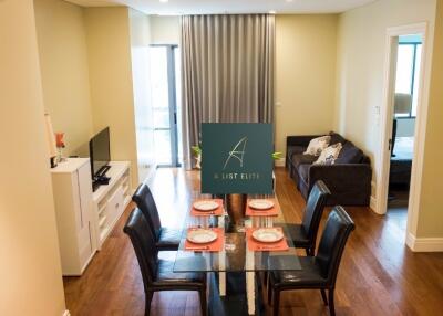 Bright dining area adjacent to cozy living space with a couch and TV