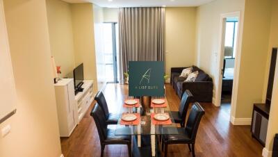 Bright dining area adjacent to cozy living space with a couch and TV