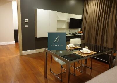 Modern dining area with wooden floor and wall-mounted TV