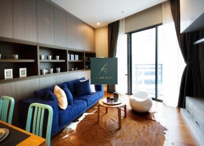 Modern living room with blue sofa, wooden furniture, and large windows