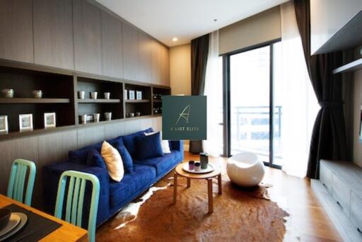 Modern living room with blue sofa, wooden furniture, and large windows