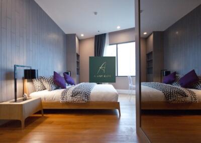 Modern bedroom with mirrored closet, king-size bed, and wooden flooring