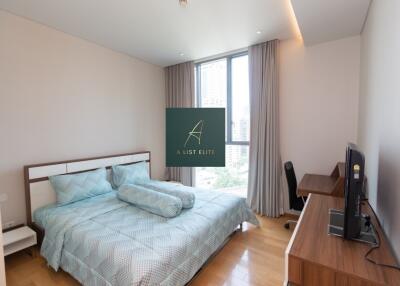 Modern bedroom with large window, desk, and double bed with blue bedding