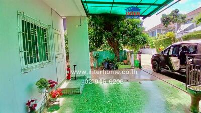 Front of a house with green tiled flooring and a car parked in the driveway