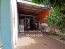 Covered outdoor area with a washing machine and hanging clothes.