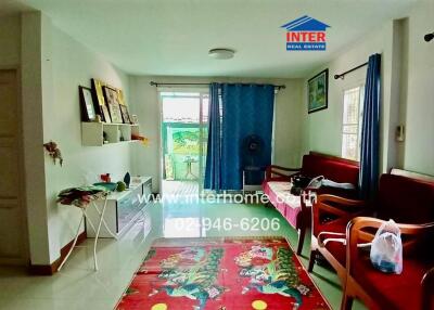 Bright living room with furniture, shelves, and large windows