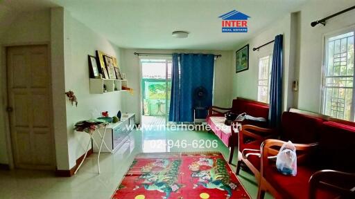 Bright living room with furniture, shelves, and large windows