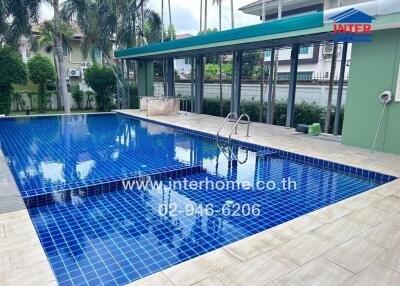 Outdoor swimming pool with blue tile surround and ladder