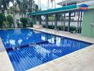 Outdoor swimming pool with blue tile surround and ladder