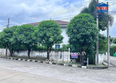 Exterior view of a residential building with trees and street