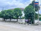 Exterior view of a residential building with trees and street