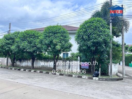 Exterior view of a residential building with trees and street