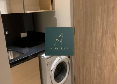 Laundry room with washing machine and wooden cabinets