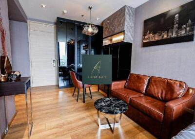 A modern living room with wooden flooring, leather sofa, marble coffee table, and wall art