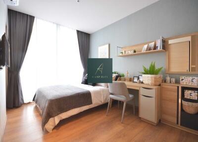 Contemporary bedroom with a bed, study desk, and large window with curtains