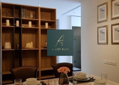 Dining area with table set for four, decorative shelving, and pendant lighting