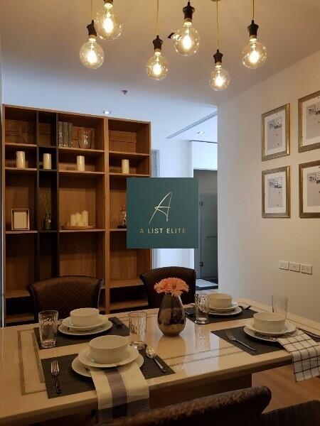 Dining area with table set for four, decorative shelving, and pendant lighting