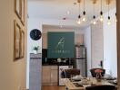 Modern kitchen and dining area with wooden flooring, paintings, and decorative lighting.