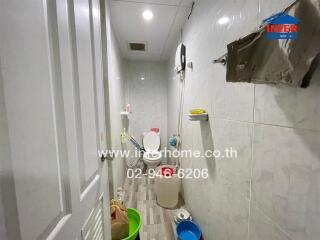 A small bathroom with various toiletries and cleaning supplies