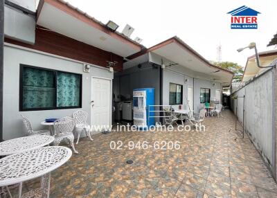 Outdoor seating area with tables and chairs in front of a building