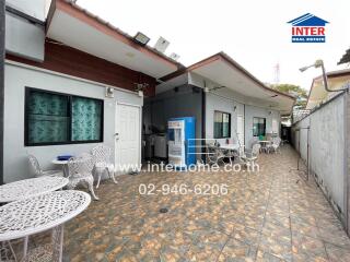 Outdoor seating area with tables and chairs in front of a building