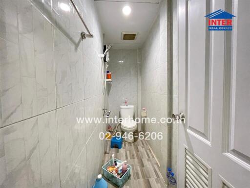 narrow bathroom with toilet and tiled walls