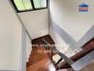 A wooden staircase with metal railings leading down to the lower floor.