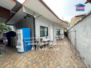 Covered outdoor area with tiled floor, sitting space, and utility area