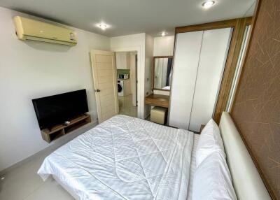 Modern bedroom with television, air conditioning, and comfortable bed