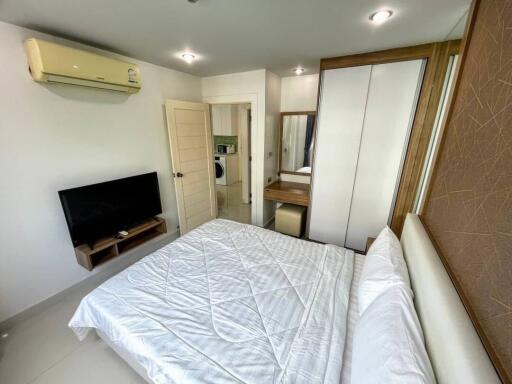 Modern bedroom with television, air conditioning, and comfortable bed