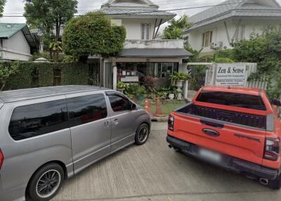 Exterior view of a residential building with parked vehicles