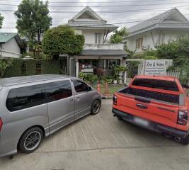 Exterior view of a residential building with parked vehicles