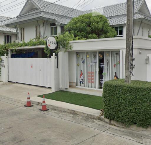 Exterior view of a white residential house with a gated entrance