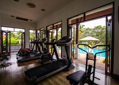 Home gym with exercise equipment and view of swimming pool